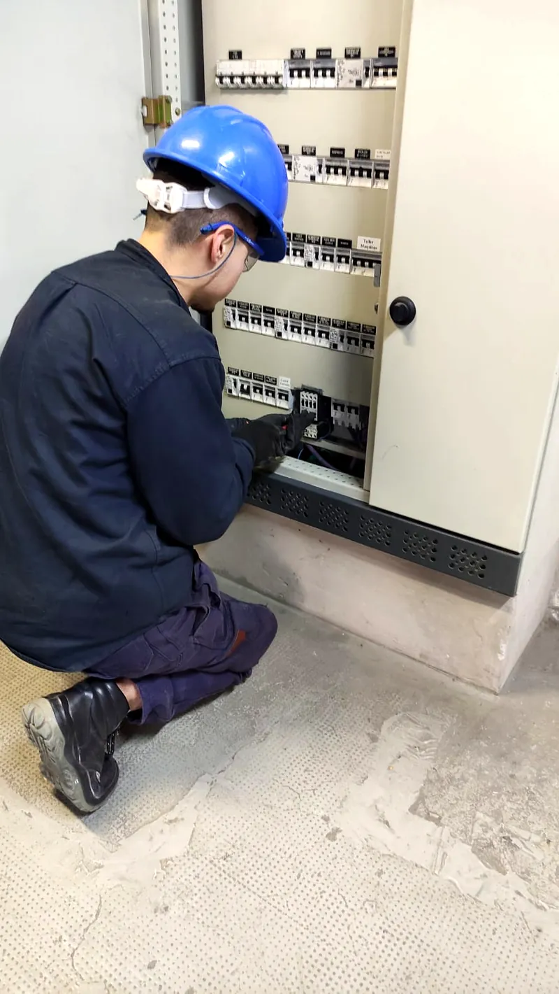 Técnico con casco revisando un tablero seccional durante una visita de mantenimiento preventivo